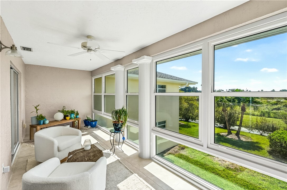 475 Grove Isle Circle, Unit 475 Vero Beach, FL 32962 - Photo 14 of 36 a living room with furniture and a floor to ceiling window