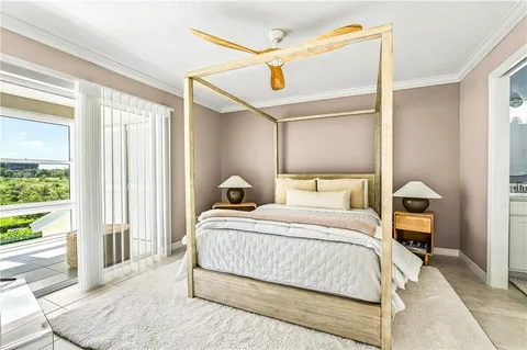 a bedroom with a bed and a large window