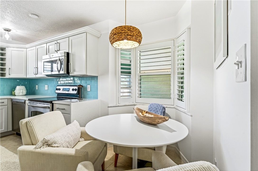 475 Grove Isle Circle, Unit 475 Vero Beach, FL 32962 - Photo 8 of 36 a living room with furniture a window and a fireplace