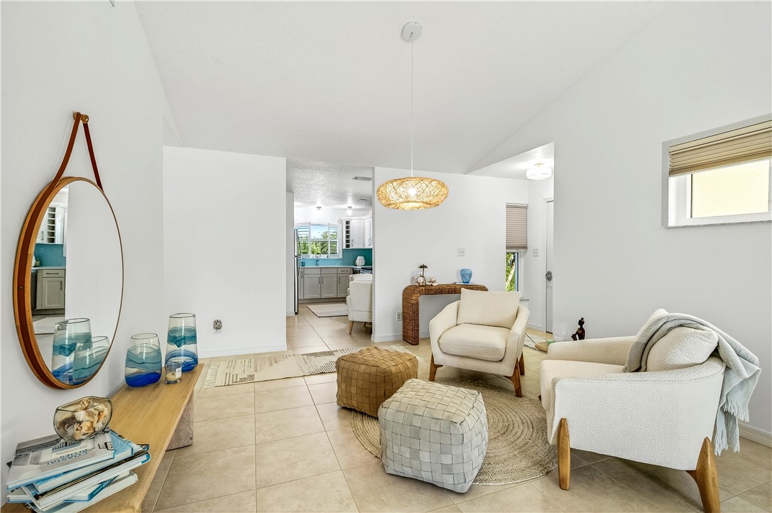 475 Grove Isle Circle, Unit 475 Vero Beach, FL 32962 - Photo 10 of 36 a living room with furniture and a large mirror