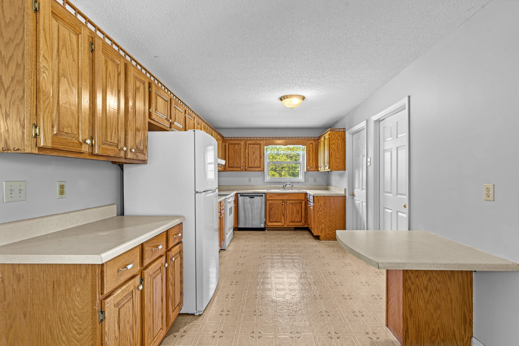 1235 Yell Road Lewisburg, TN 37091 - Photo 27 of 36 a kitchen with a refrigerator a sink and wooden cabinets