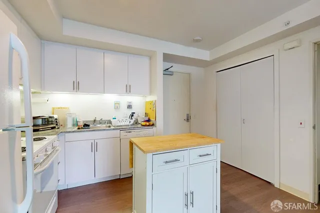 a kitchen with a sink cabinets and wooden floor