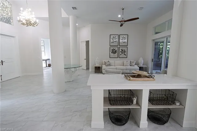 a view of a hallway with furniture and a chandelier