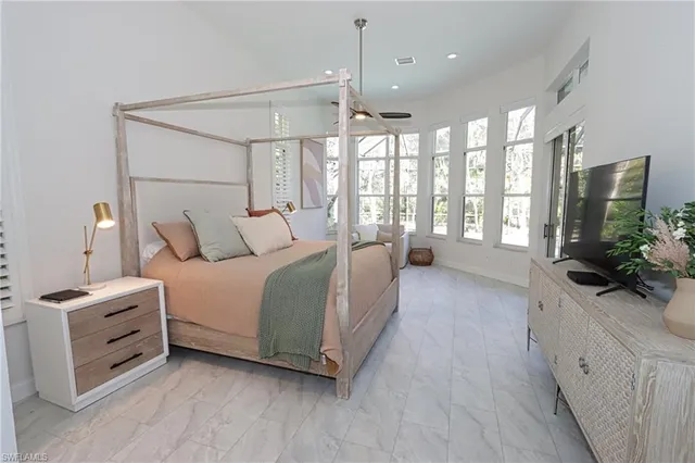 a spacious bedroom with a large bed and a chandelier