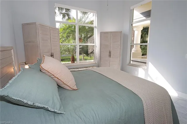 a bedroom with a bed and a large window