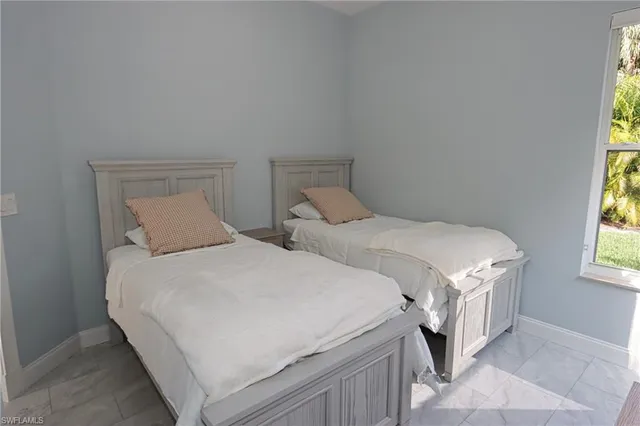 a bedroom with two beds and a window