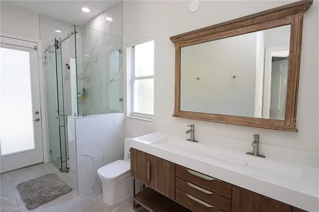 a bathroom with a sink a toilet and shower