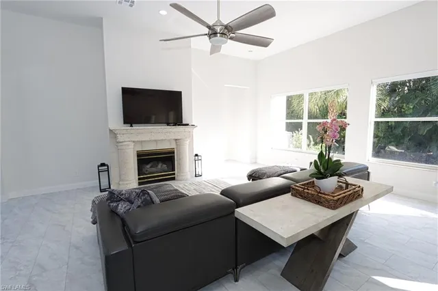 a living room with furniture a flat screen tv and a fireplace