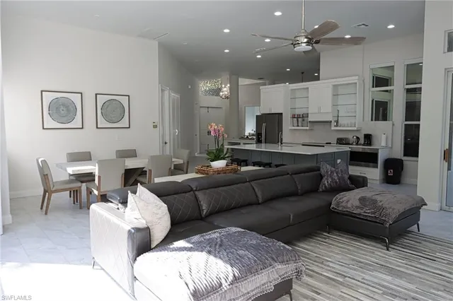 a living room with furniture kitchen view and a chandelier