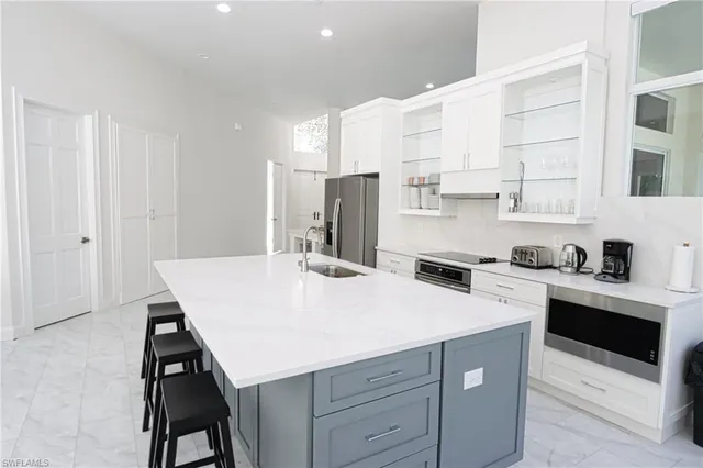 a kitchen with a sink a stove and white cabinets