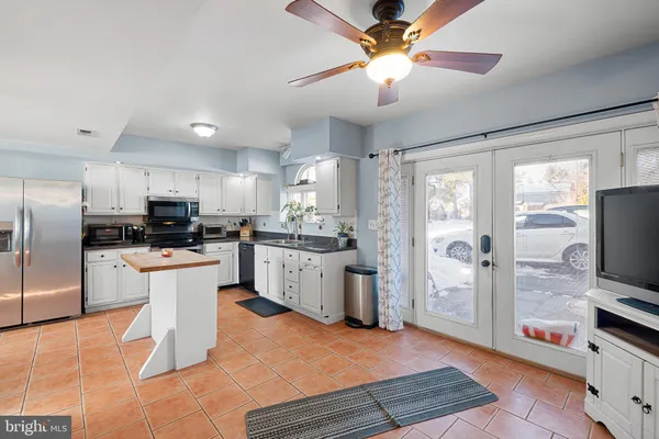 a kitchen with stainless steel appliances kitchen island granite countertop a refrigerator and a sink