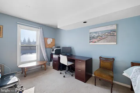 a view of a workspace with furniture and a window