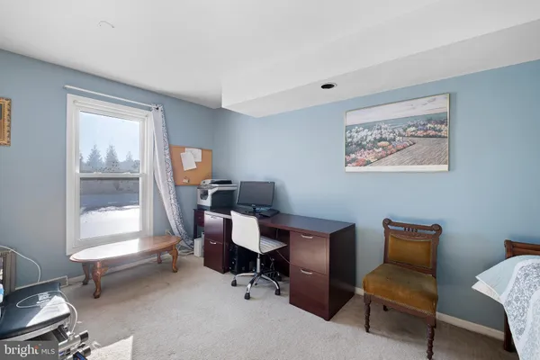 a view of a workspace with furniture and a window