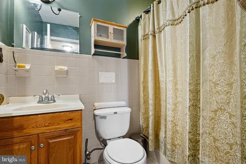 a bathroom with a granite countertop toilet sink and mirror