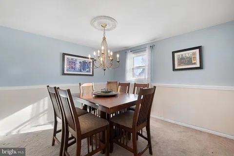 a view of a dining room with furniture a chandelier and wooden floor