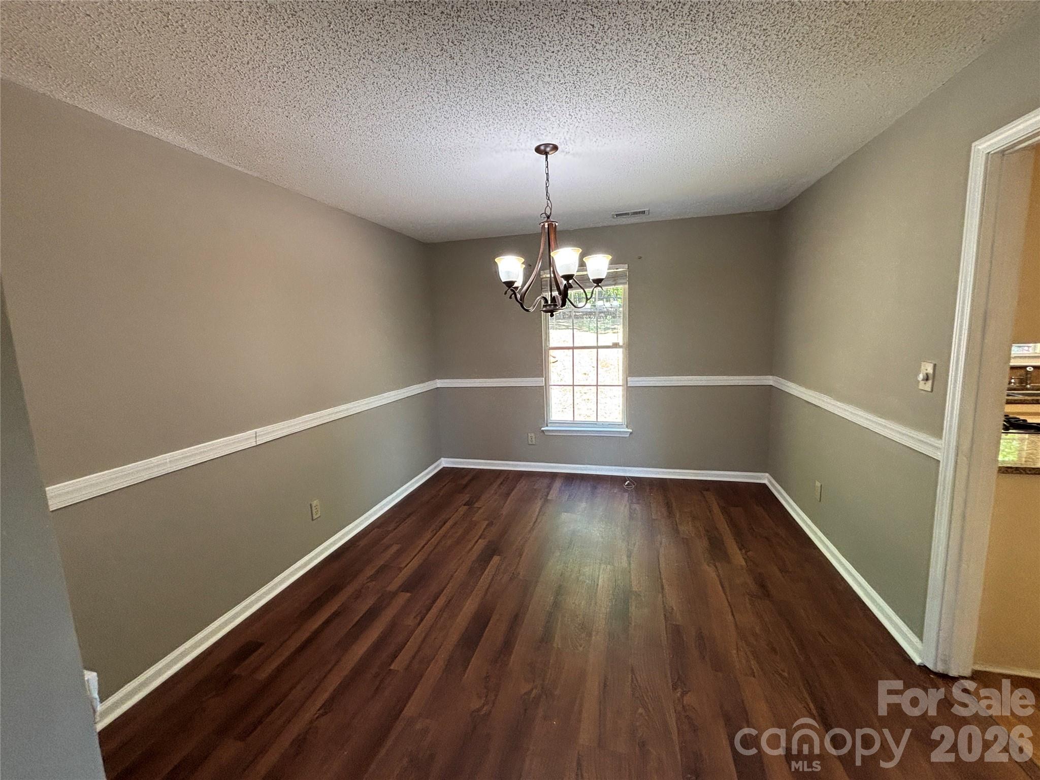 2601 Yarrow Road Charlotte, NC 28213 - Photo 10 of 40 a view of an empty room with wooden floor and a window