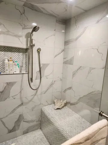 a bathroom with a granite countertop shower a sink and a mirror