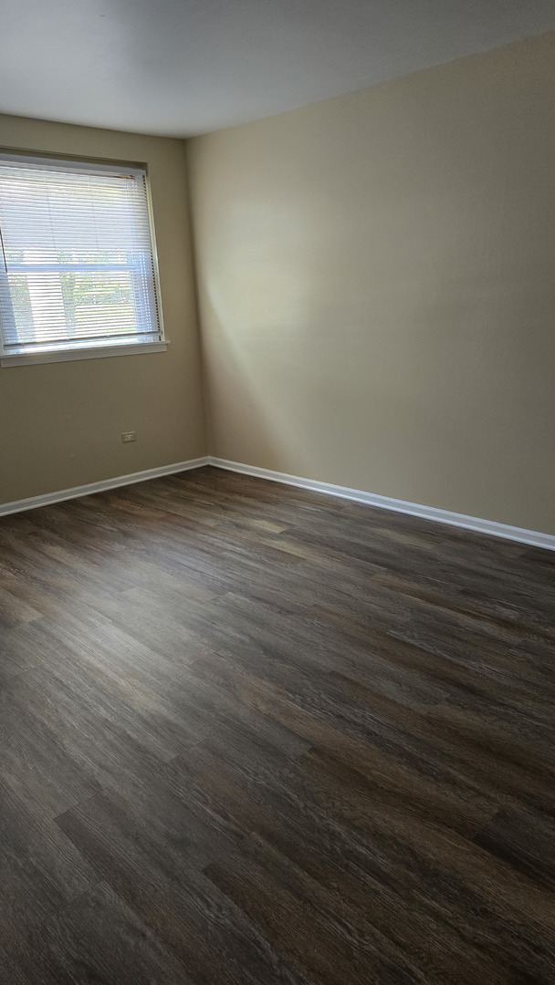 4052 Charleston Road, Unit 2E Matteson, IL 60443 - Photo 2 of 5 an empty room with wooden floor and windows