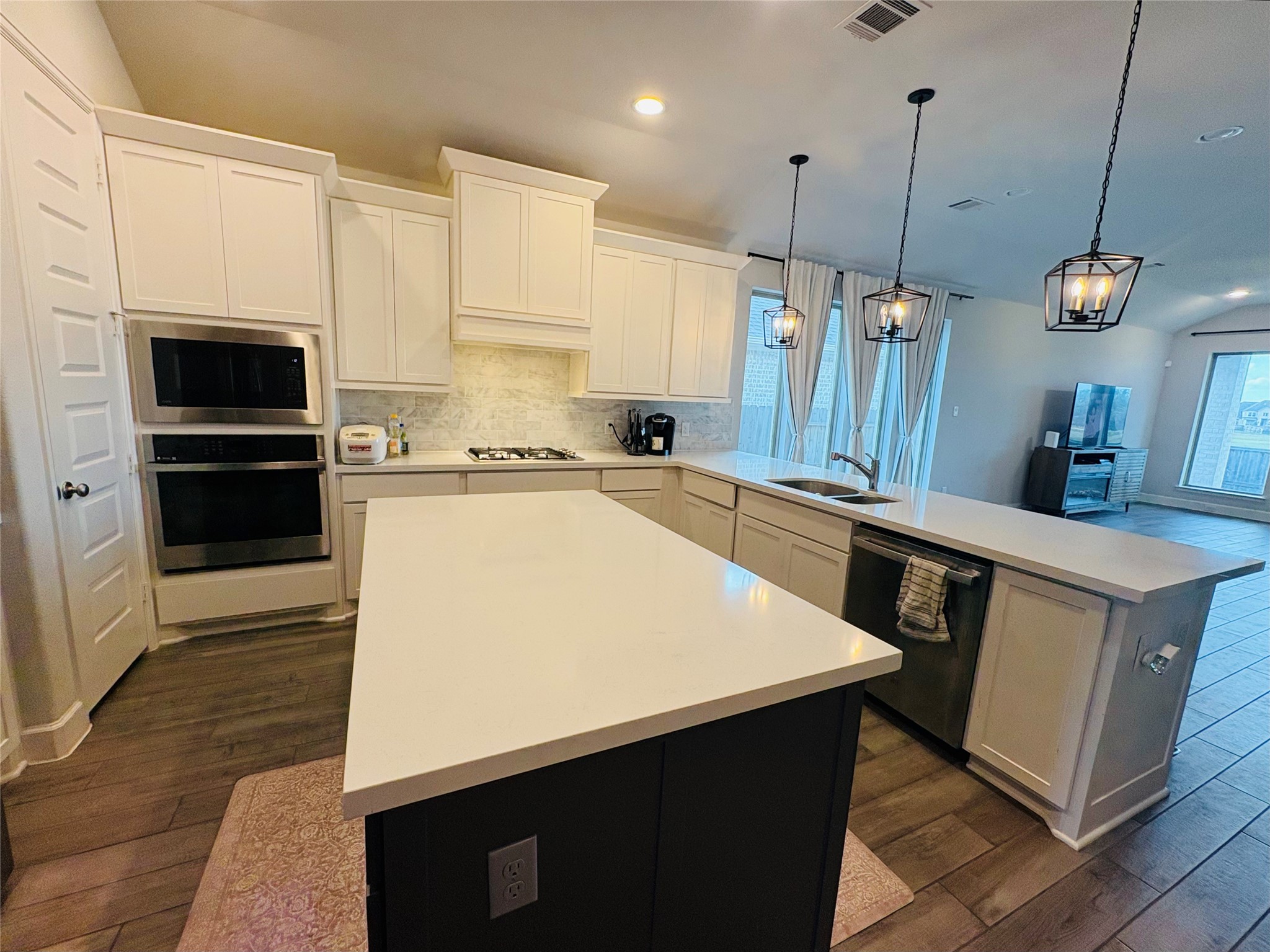 42550 Summer Crest Road Magnolia, TX 77354 - Photo 6 of 15 a kitchen with stainless steel appliances a stove a sink dishwasher a refrigerator white cabinets and wooden floor