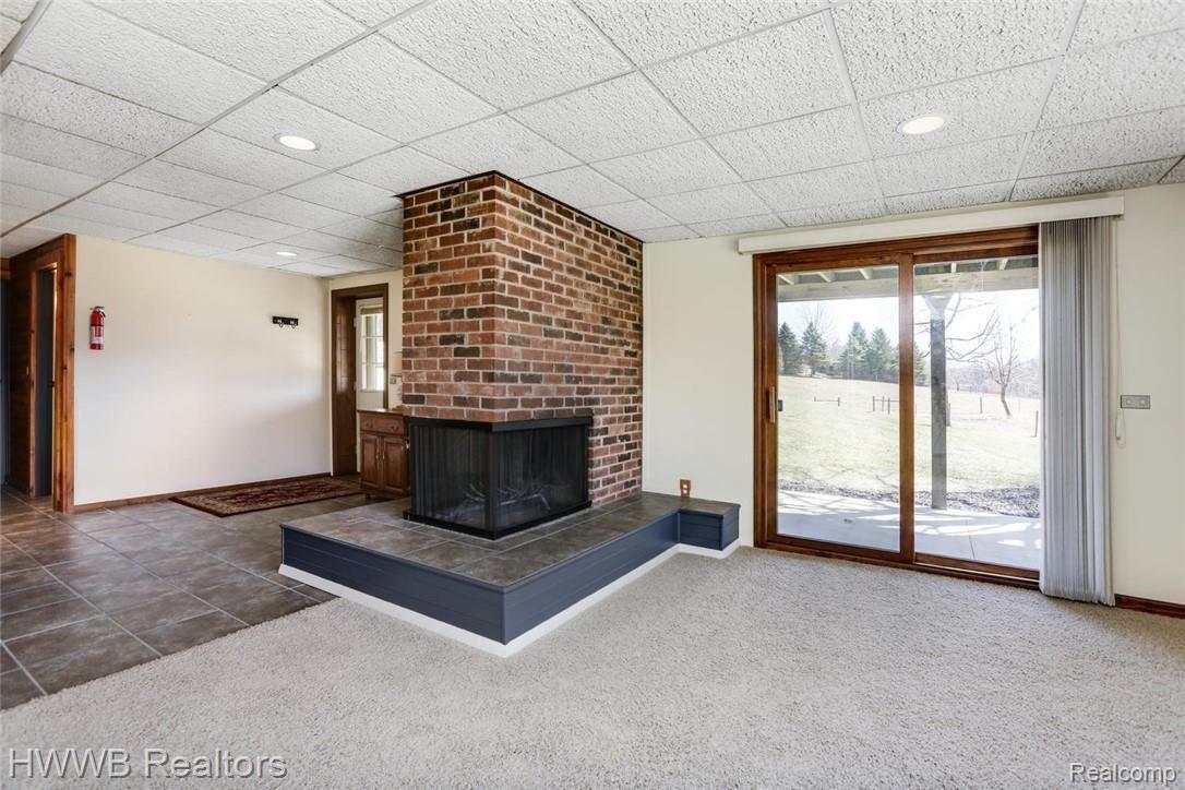 6200 Mack Road Howell, MI 48855 - Photo 34 of 52 The family room also enjoys its own three-sided wood-burning fireplace.