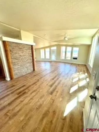 a living room with stainless steel appliances kitchen island wooden floors and view kitchen