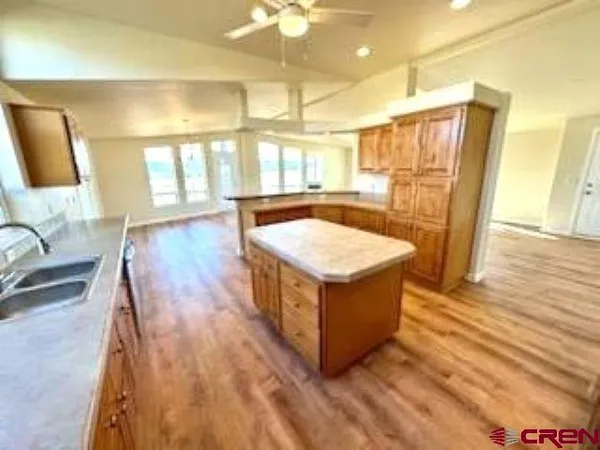 a kitchen with stainless steel appliances granite countertop a refrigerator a stove and a sink
