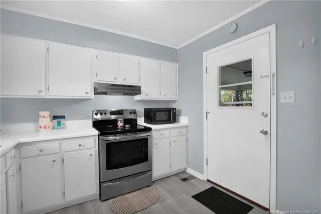 a kitchen with cabinets stainless steel appliances and a counter space