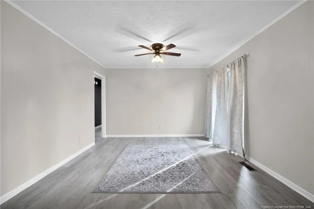 an empty room with fan and windows