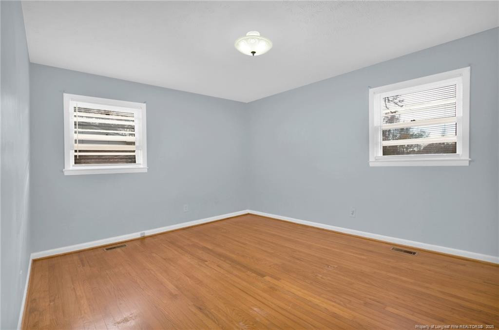 623 Isaac Weeks Road Clinton, NC 28328 - Photo 19 of 24 a view of an empty room with wooden floor and a window
