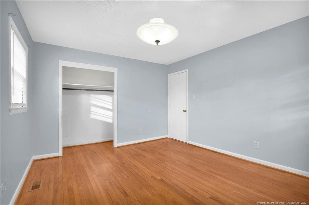 623 Isaac Weeks Road Clinton, NC 28328 - Photo 20 of 24 an empty room with wooden floor and windows