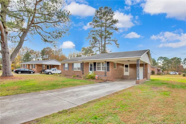 a front view of a house with a yard and trees