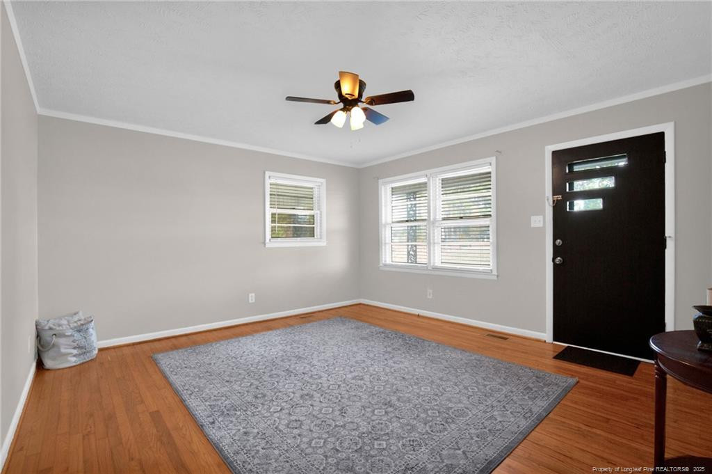 623 Isaac Weeks Road Clinton, NC 28328 - Photo 6 of 24 a view of empty room with wooden floor and fan