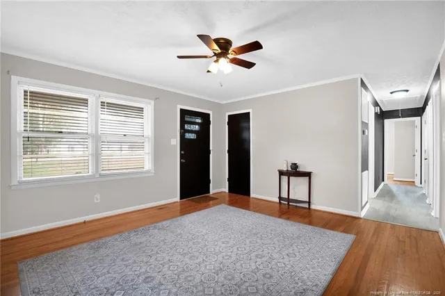 a workspace with wooden floor a ceiling fan and windows