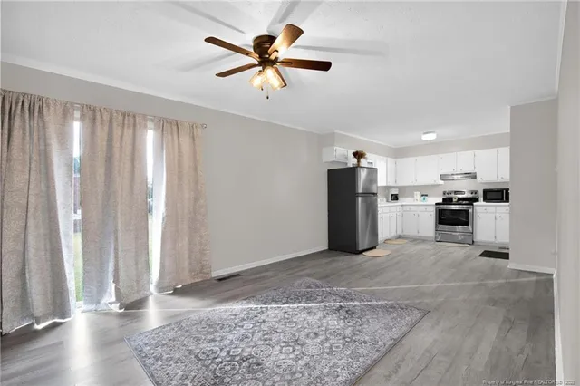 a view of kitchen with stainless steel appliances granite countertop cabinets and wooden floor
