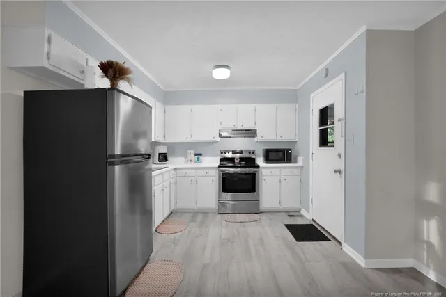 a kitchen with white cabinets and stainless steel appliances