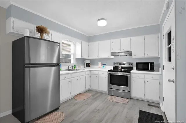 a kitchen with white cabinets and stainless steel appliances