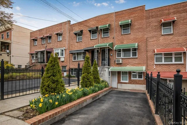 a front view of a house with a yard and potted plants