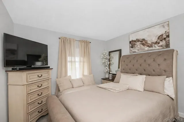 a bedroom with a large bed and a flat screen tv