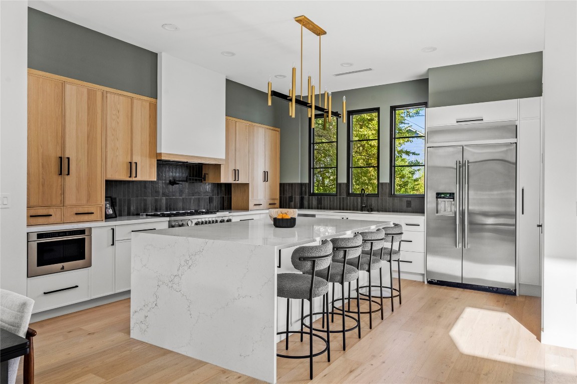 a kitchen with stainless steel appliances a stove a refrigerator and a kitchen island
