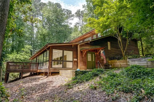 a backyard of a house with wooden fence and large trees