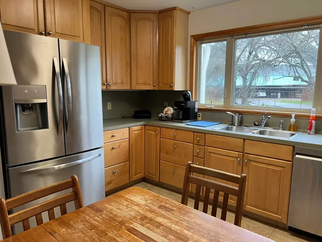 a kitchen with white cabinets and refrigerator