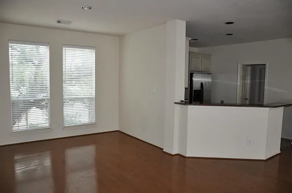 a view of a kitchen with wooden floor and a window