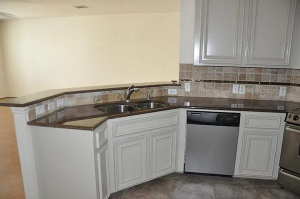 a kitchen with granite countertop white cabinets and white appliances