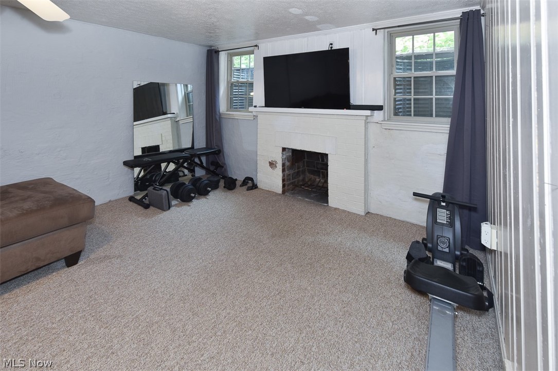 2559 Channing Road Cleveland, OH 44118 - Photo 24 of 28 Living room featuring carpet flooring, a textured ceiling, and a brick fireplace