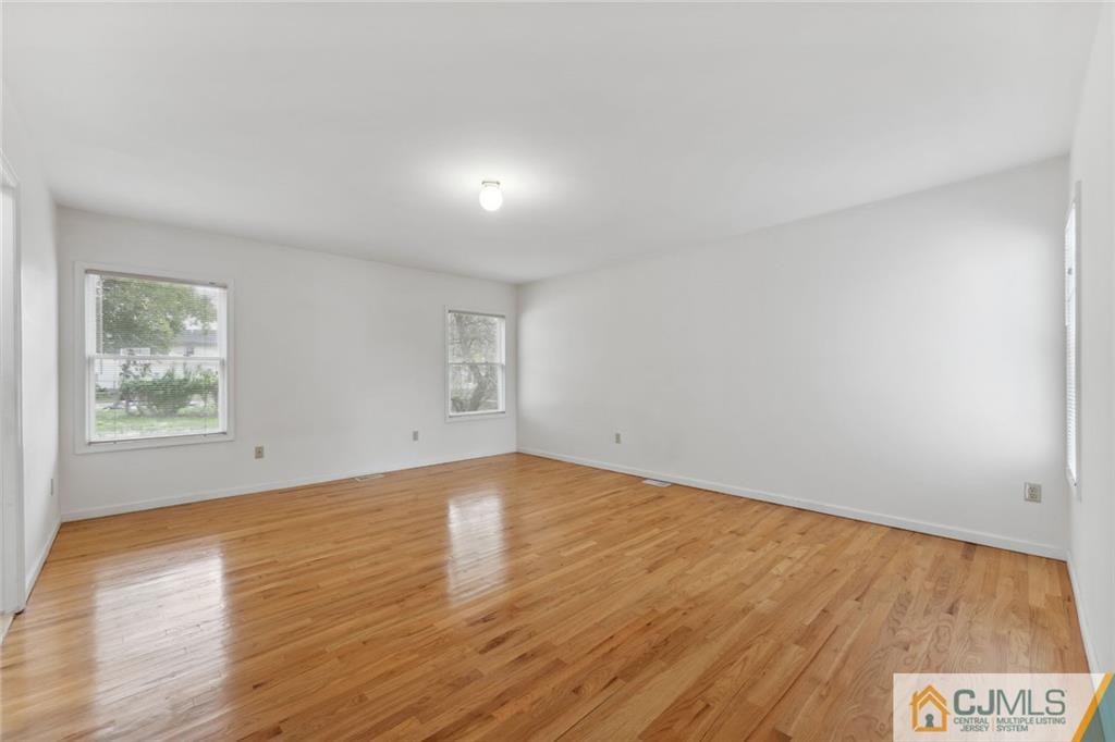 8 Longfellow Drive Colonia, NJ 07067 - Photo 11 of 25 an empty room with wooden floor and windows