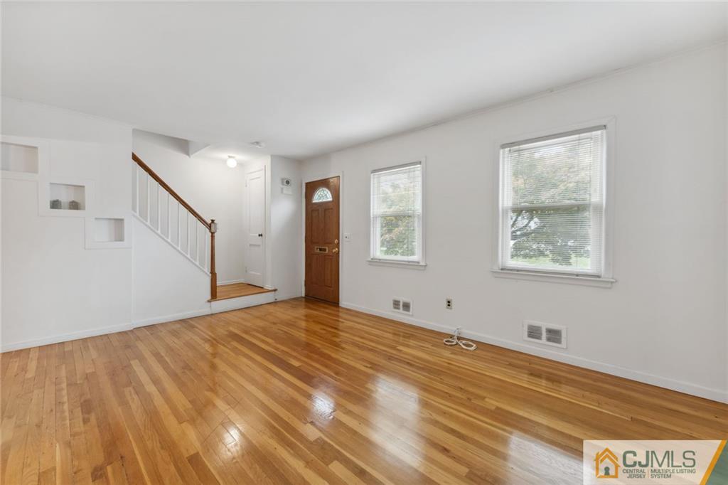 8 Longfellow Drive Colonia, NJ 07067 - Photo 2 of 25 a view of an empty room with wooden floor and a window