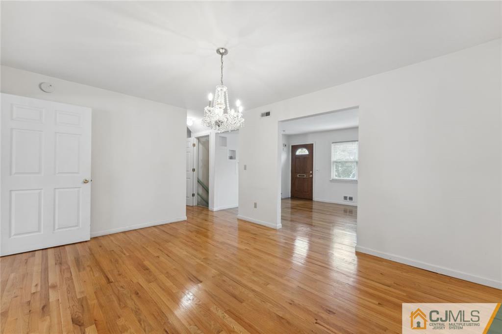 8 Longfellow Drive Colonia, NJ 07067 - Photo 4 of 25 a view of a hallway with wooden floor and chandelier