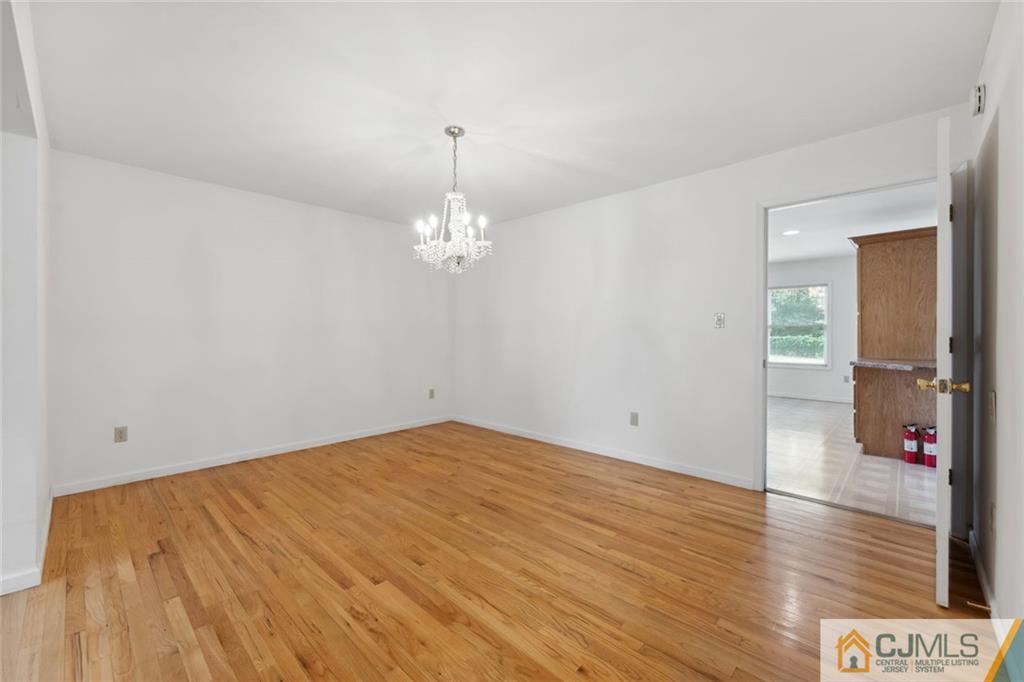 8 Longfellow Drive Colonia, NJ 07067 - Photo 5 of 25 wooden floor in an empty room with a chandelier