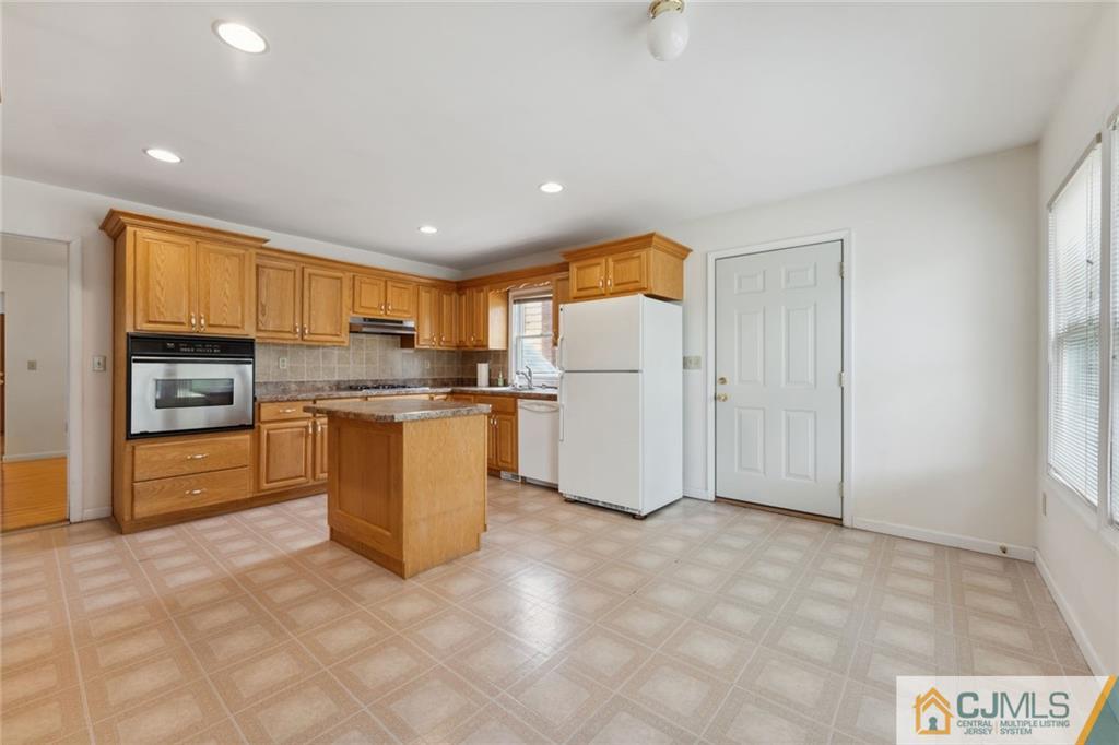 8 Longfellow Drive Colonia, NJ 07067 - Photo 6 of 25 a kitchen with stainless steel appliances granite countertop a refrigerator and a stove top oven
