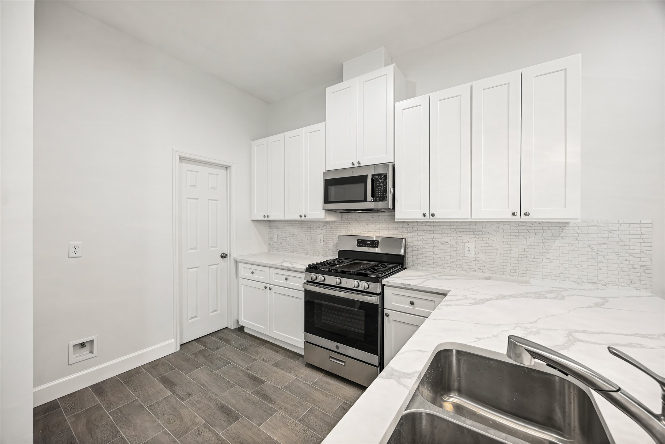 1546 Lombardy Street Houston, TX 77023 - Photo 8 of 15 a kitchen with granite countertop white cabinets and stainless steel appliances